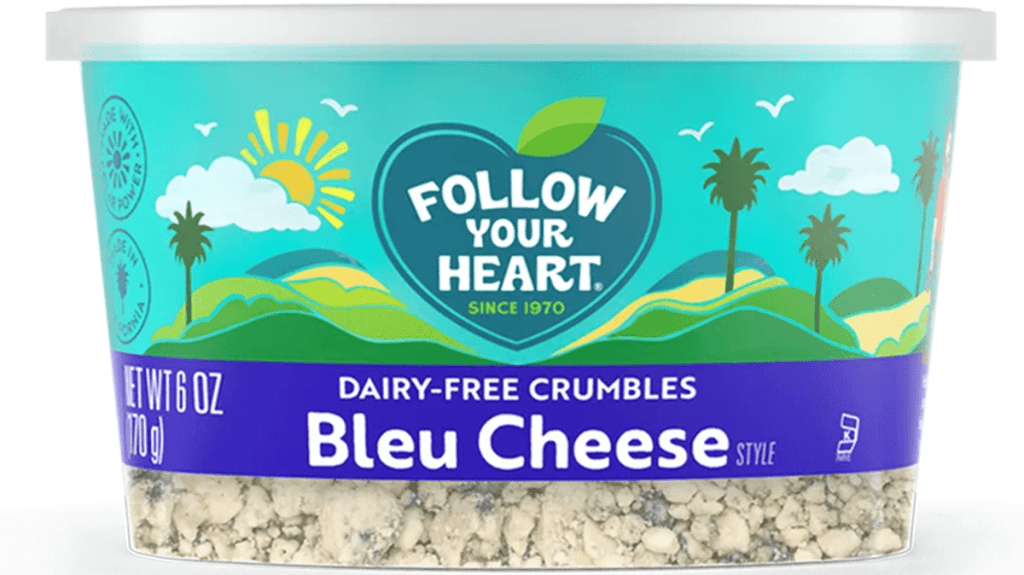 A picture of Follow Your Heart bleu cheese, dairy-free crumbles in a plastic tub. Blue cheese